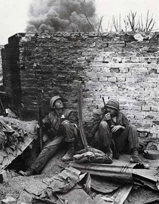 US Marines shelter by a wall in Hue during the Tet Offensive